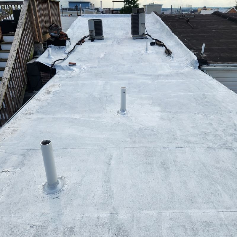 Coated flat roof with sealed pipe flashings