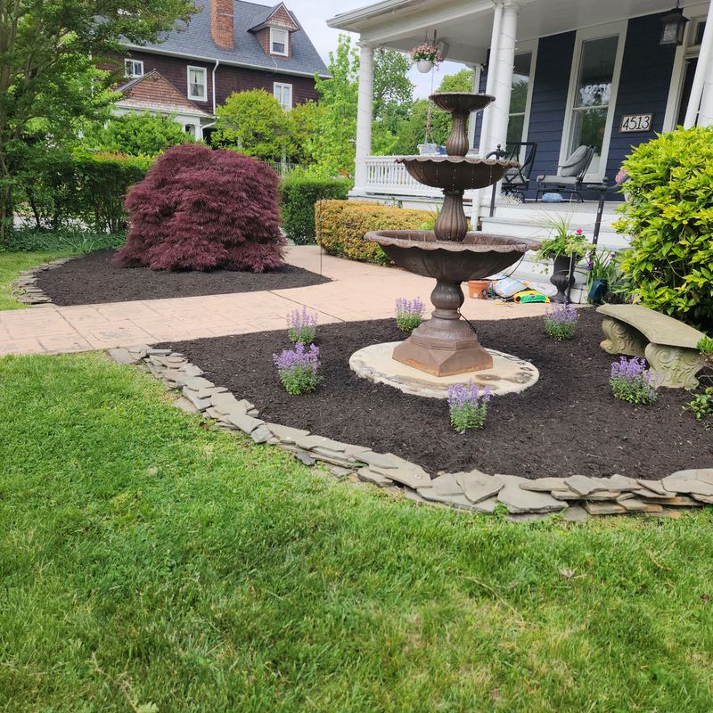 Front yard fountain with stone edging and plantings